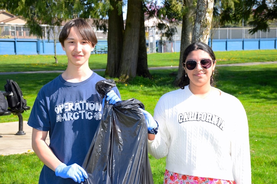 Delview Leos Club president Joshua Thoreson (left) and founder Kookie Sethi collect litter at North Delta's Delview Park on Tuesday, April 22, 2025 as part of the group's third annual Earth Day cleanup.