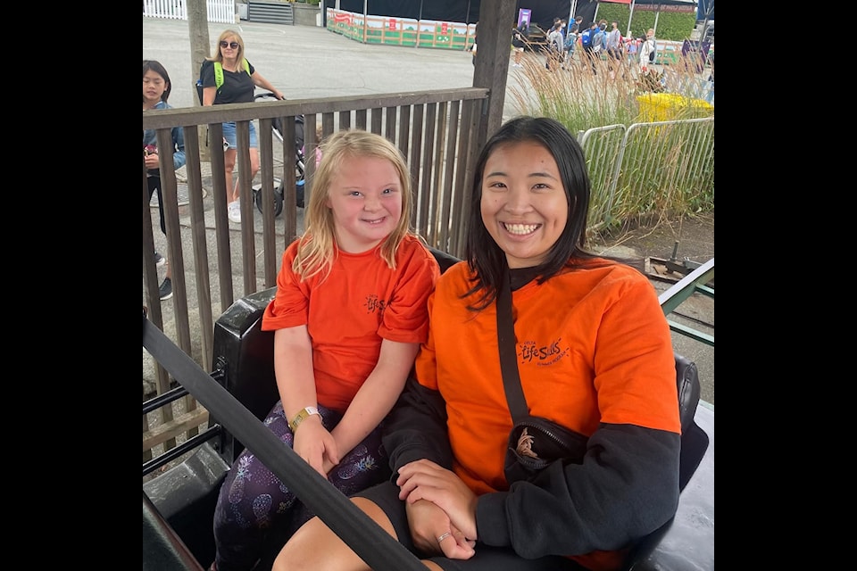 A camper and support worker enjoy a ride at Playland during an excursion with Delta Life Skills Society's 2024 summer day camp program.