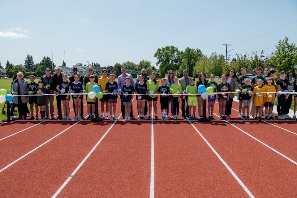 Representatives from the City of Delta, Delta School District, provincial government and Tsawwassen First Nation celebrate the grand opening of Delta Secondary's new track and field, joined by students from the high school and nearby elementaries in Ladner, on Monday, June 2, 2025.