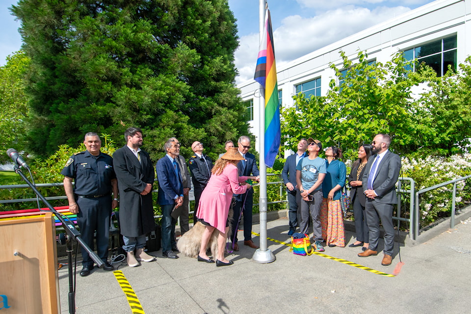 Tsawwassen First Nation Executive Coun. Valerie Cross and Delta Mayor George Harvie raise the Progress Pride flag outside Delta City Hall on Monday, May 26, 2025. Pictured around them are (from left) Delta Police Chief Const. Harj Sidhu, Musqueam Indian Band Coun. Alec Guerin, Delta school board chair Joe Muego, Delta Coun. Jessie Dosanjh, Delta Fire Chief Guy McKintuck, councillors Daniel Boisvert and Rod Binder, Delta Pride Society board member Carol Johnson, Sher Vancouver community engagement manager Joshna Hirani, and councillors Jennifer Johal and Dylan Kruger.