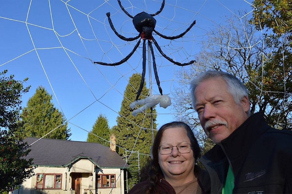 Cloverdale couple Kevin and Traci Penner pose with their giant spider Halloween display. (Photo: Tom Zytaruk)
