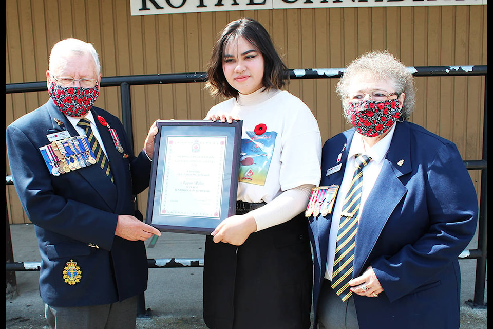 Anggun Rabu receives an award Aug. 12 from the Cloverdale Legion’s Earle Fraser and Pat Keeping. Rabu won first place in the senior colour poster category of the Canadian Legion’s national contest. Along with the award, Rabu won a trip to Ottawa for the Remembrance Day Ceremony on November 11. Her school Ecole Gabrielle-Roy will also receive a plaque. (Photo: Submitted)