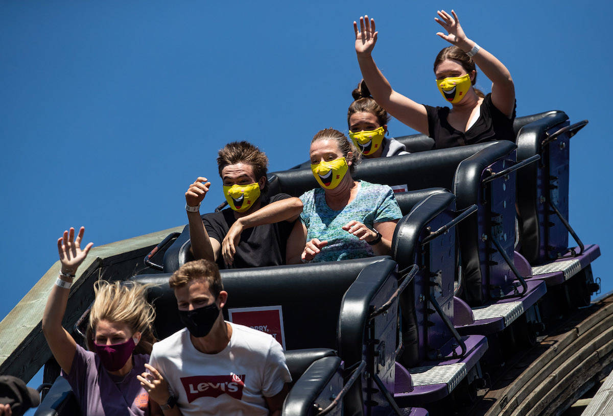 People wear face masks while riding the wooden roller coaster at Playland amusement park at the Pacific National Exhibition. (Darryl Dyck)