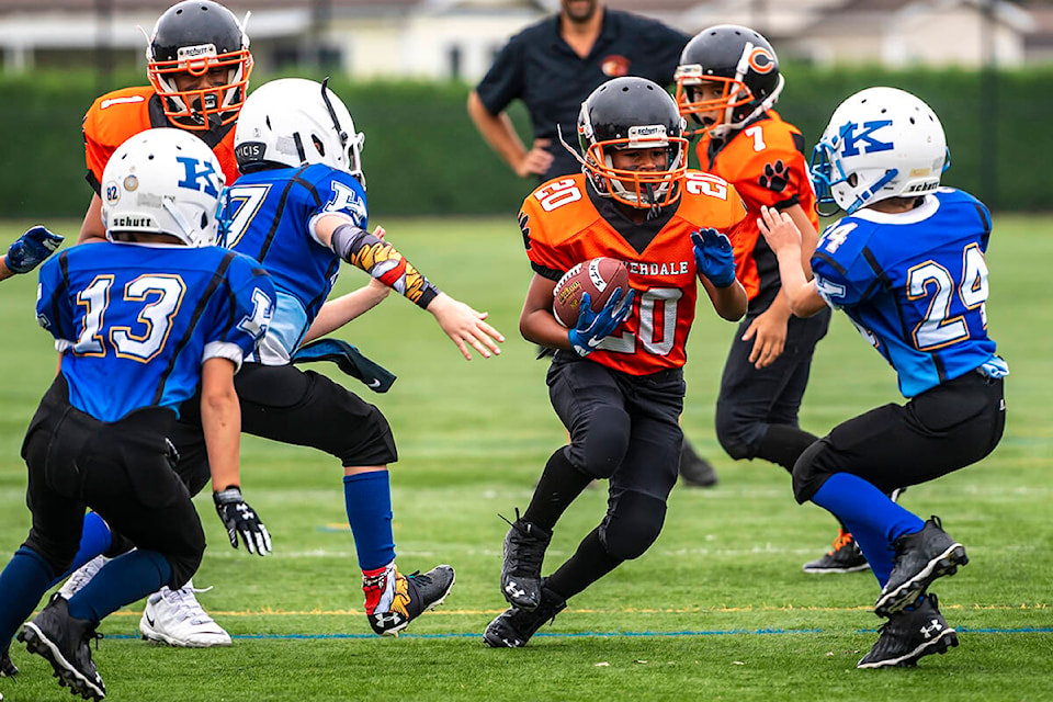Bryson Osei, number 20 on the Cloverdale Atom Lions, darts through an opening in the line in a game at the Chilli Bowl tournament Aug. 21 in Chilliwack. (Photo: Rick McDonald/ Courtesy Cloverdale Community Football Association)