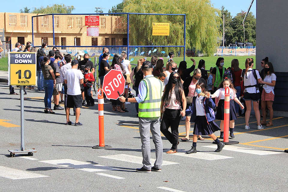 Clive Heah, principal of Cloverdale Catholic School, performs crossing guard duties on the first day of the new school year. Classes ended at noon on the first day. (Photo: Malin Jordan)