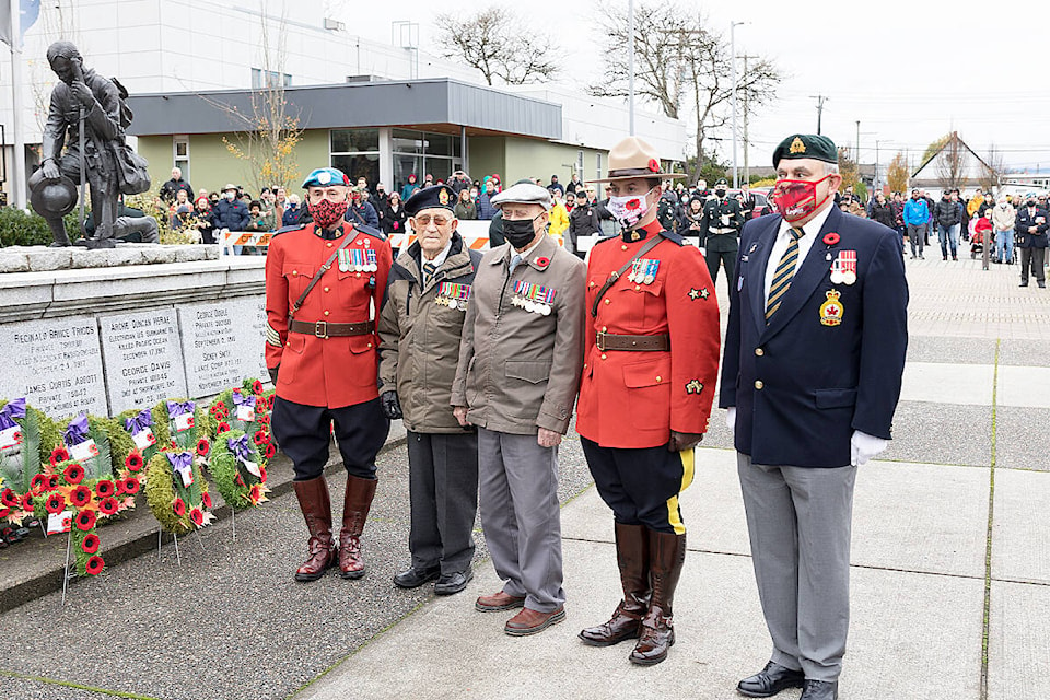 Centenarians Hans Andersen (middle left) and Dick Deck stand with Legion representative Laurier “Duke” Cadieux (right) and two RCMP officers Nov. 11, 2021. The two 100-year-olds had both laid wreaths at the Cloverdale Cenotaph. Both men were POWs in WWII. (Photo: Jason Sveinson)
