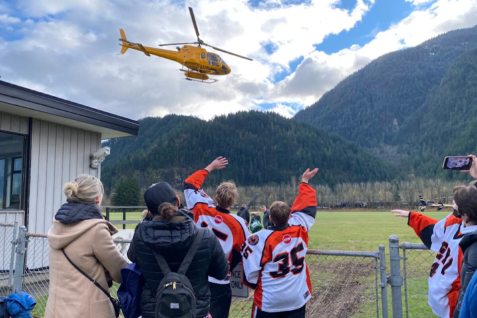 Members of the Semiahmoo U15 A2 team wave to one of the departing helicopters Tuesday, as the team left Hope, where they’d been stranded since Sunday. (Contributed photo)