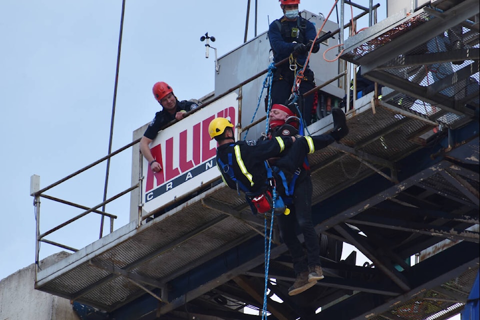 A crane operator is lowered to the ground during a high-angle rescue operation carried out in White Rock Thursday. (Brenda Anderson photo)