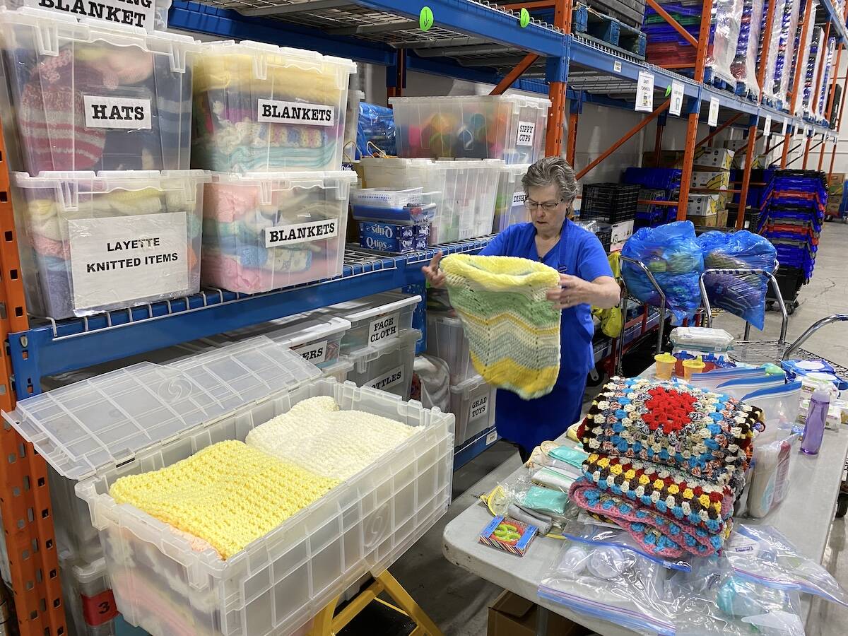 Surrey Food Bank volunteer Darlene Wickens sorts blankets to fill layette boxes for the Tiny Bundles program, for families with kids. Knitted socks and blankets are donated by local church members. (Photo: Tom Zillich)