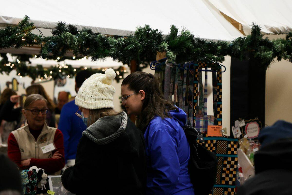 Two people viewing crafts at one of the vendors in the Christmas market in White Rock Community Centre. (Photo: Anna Burns)