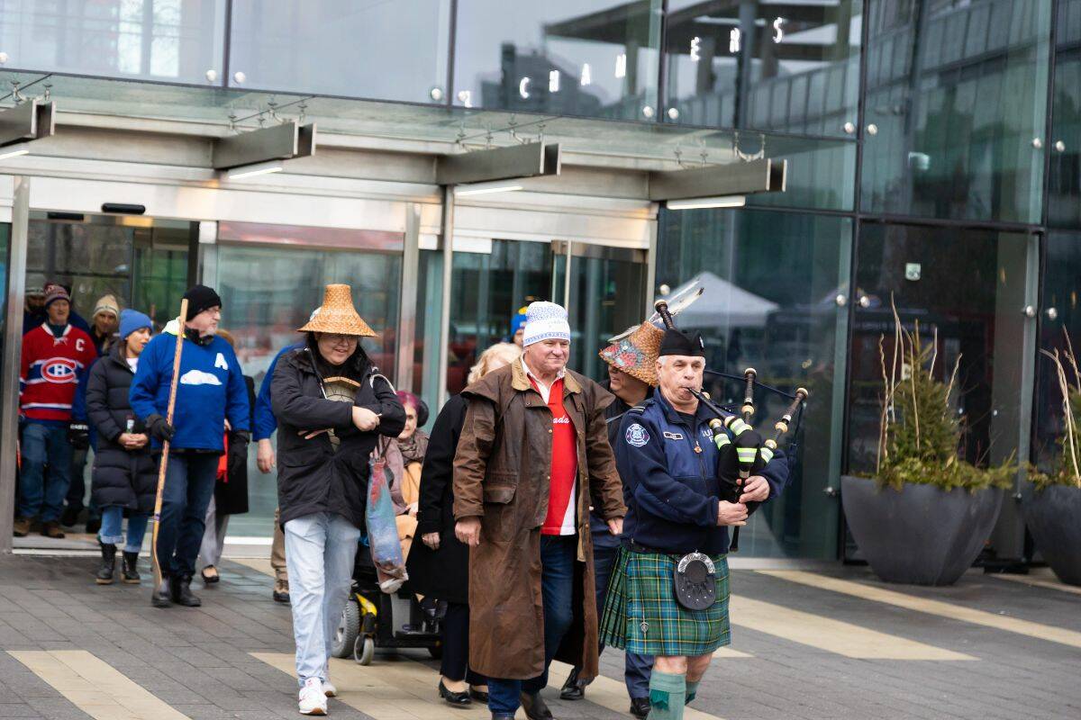 A piper leads Toque Tuesday participants from Surrey City Hall to the plaza on Tuesday, Feb. 7, 2023. (Photo: Anna Burns)