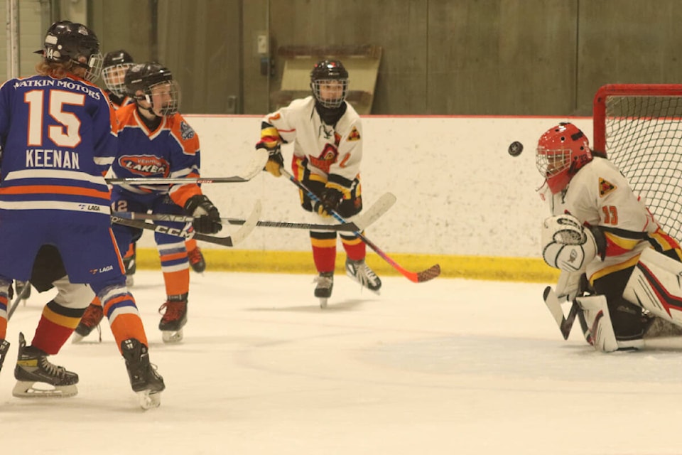 North Delta Sun Devils goalie Sofia Sangha keeps her eyes on the puck following a shot by Layten Oliver (12) of the Vernon Watkin Motors Mustangs during Vernon’s 5-2 win in the opening game of the 50th Vernon Coca-Cola Classic Pee Wee Hockey Tournament Thursday, Feb. 9, at Kal Tire Place North. (Roger Knox - Black Press)