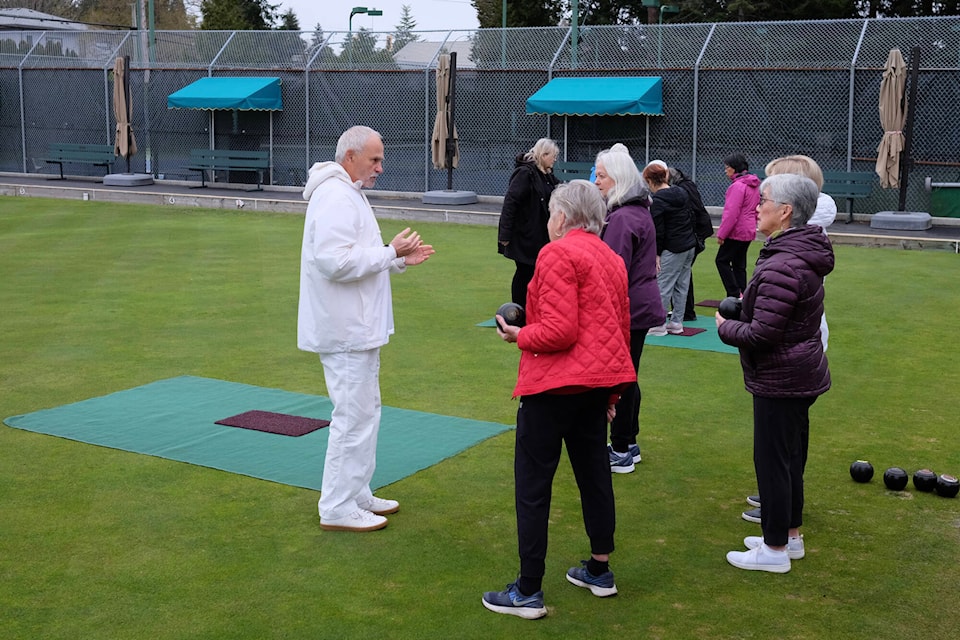 Mann Park Lawn Bowling Club coach David Tones gives some pointers on how to roll a bowl at an open house on Saturday (April 22) open house at the Centennial Park club. (Geoff Yue photo)