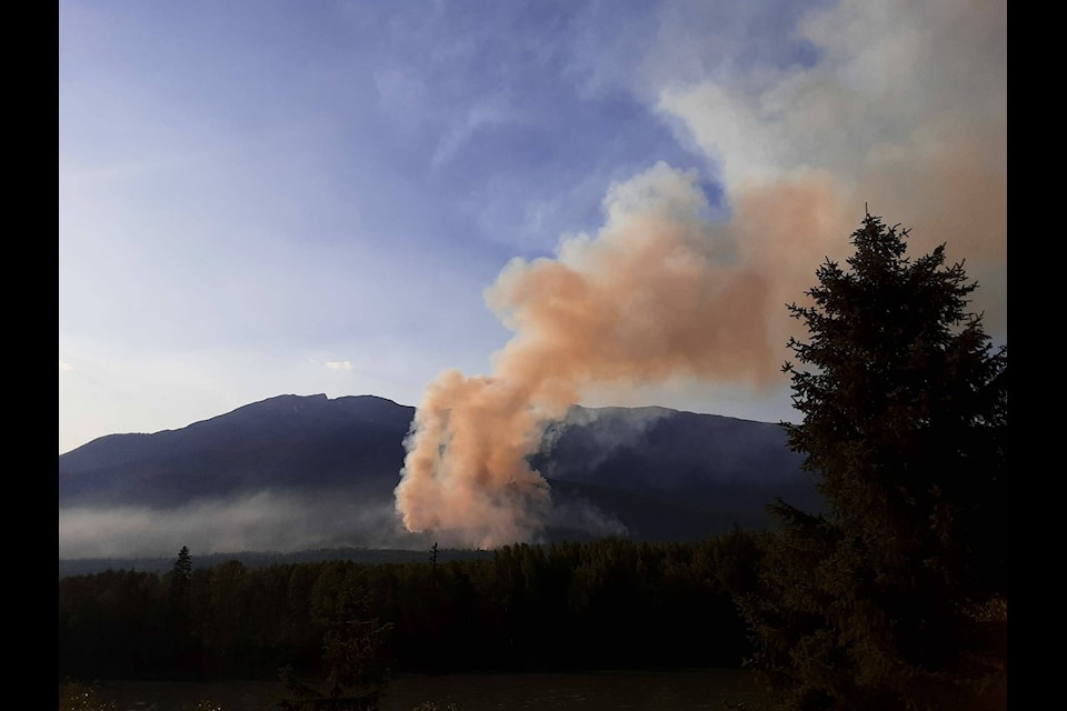 A wildfire is captured between Skeena Crossing and Cedarvale on July 13. This wildfire, suspected to be ignited by lightning, has led the Regional District of Kitimat-Stikine to issue an Evacuation Alert for residents in the Cedarvale and Woodcock area, urging them to prepare for possible evacuation. (Jerome Spence/Facebook)