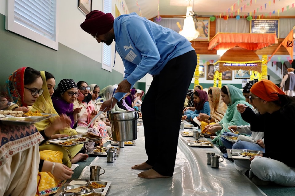 A man helps serve langar (communal meal) at the Gurdwara Sahib in Prince Rupert on April 13, 2025.