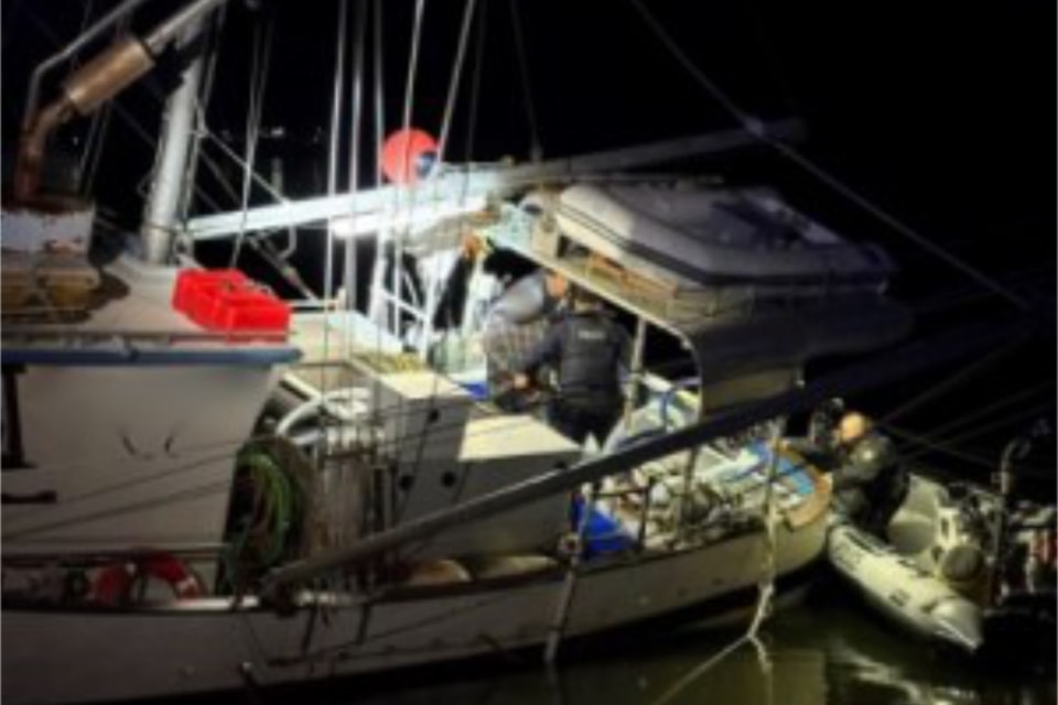Police board a stolen fishing vessel after a suspect ran it aground near Prince Rupert on June 16.