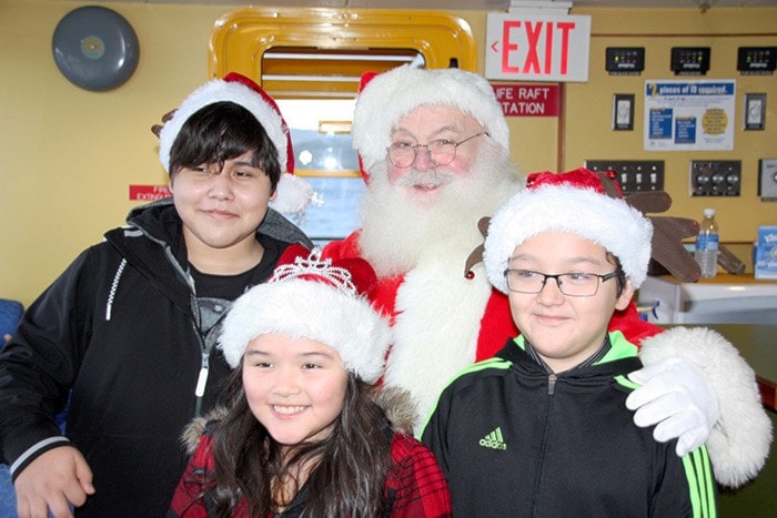 Brandon Johnson, Brooke Leask and Tyson Leask pose for a photo with Santa.