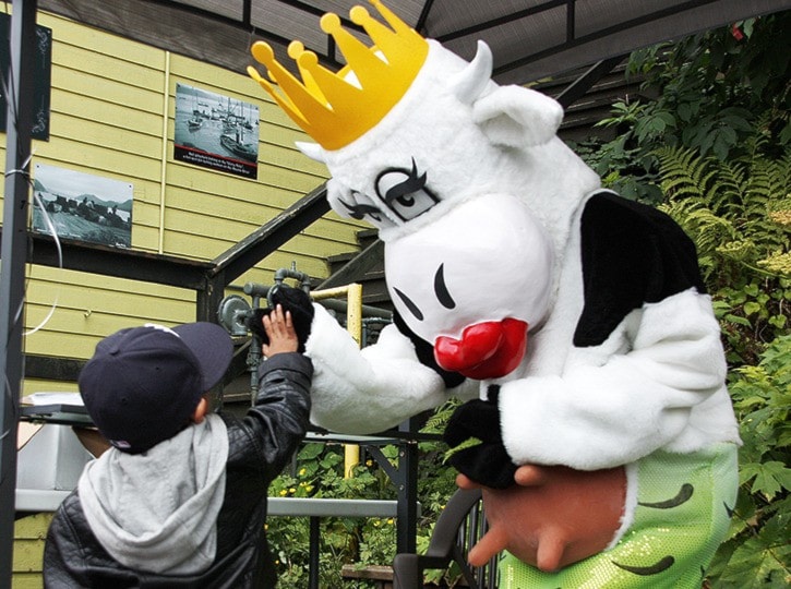 Justice, age 3, gives the MooMaid a high-five at the Kissing Booth.