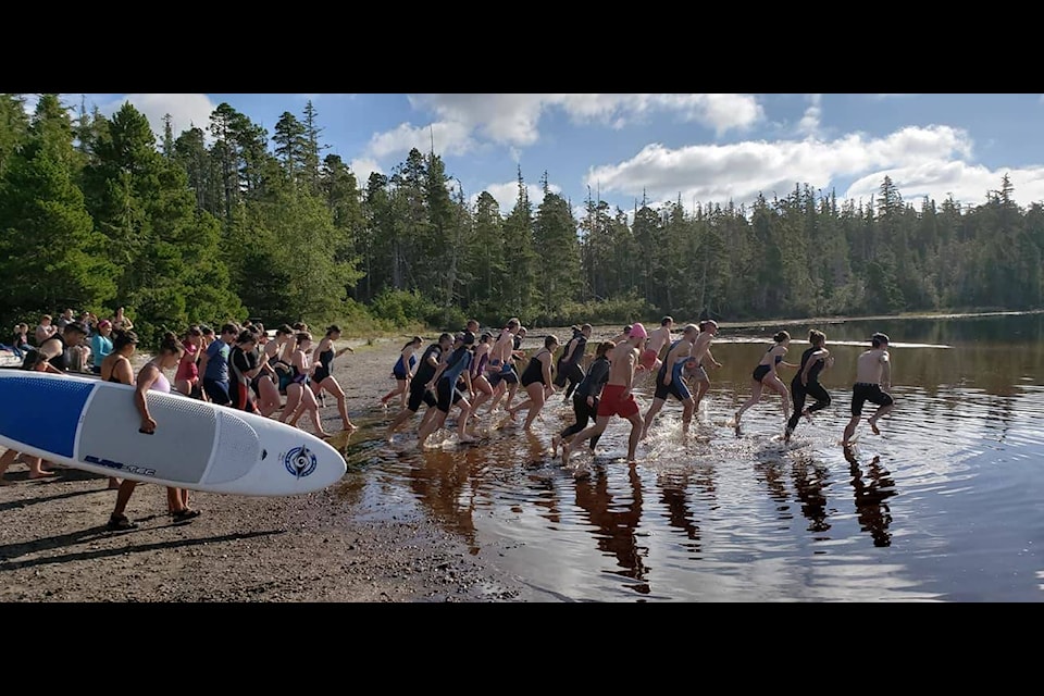With swimsuits and paddleboards, the competitors splash into a 500-metre swim in Pure Lake. (Haida Gwaii Recreation)
