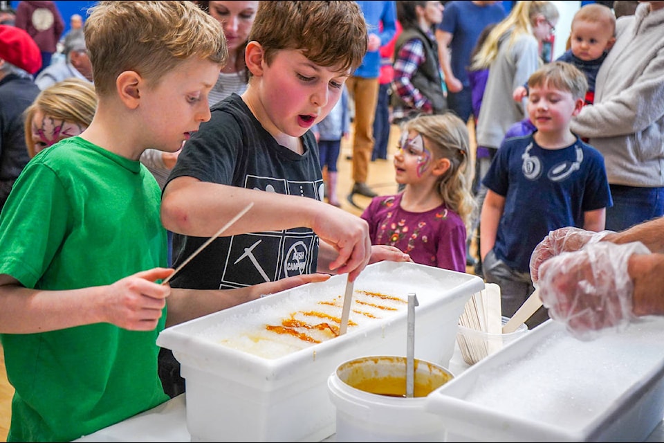Fisher Witzke, 8, and Kaeden De Araujo, 8, make maple taffy at the 9th annual Sugar Shack Brunch on Jan. 26. (Shannon Lough / The Northern View)