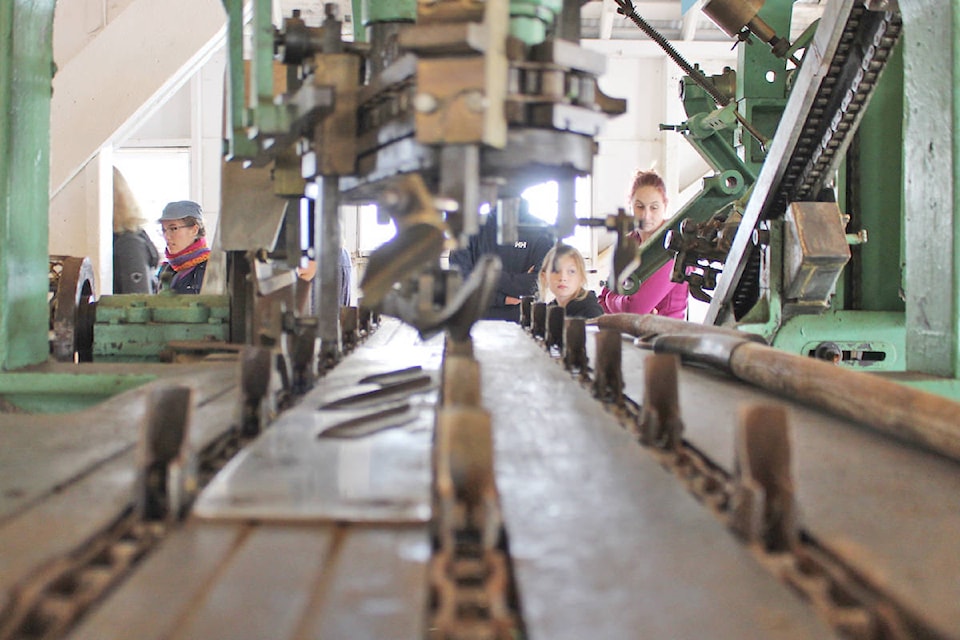 Visitors examine the cannery equipment used in the canning process. (Alex Kurial / The Northern View)