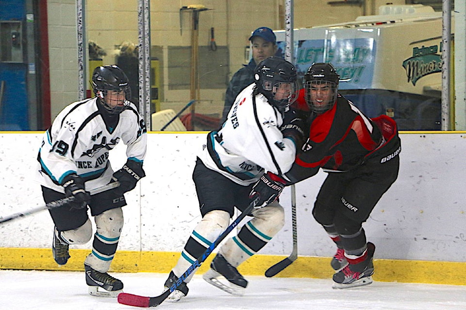 Nolan Stave (left) and Ashton Shepert won’t let Keromodes forward, Bryton Gaudet, get to the puck that easy. (Jenna Cocullo / The Northern View)