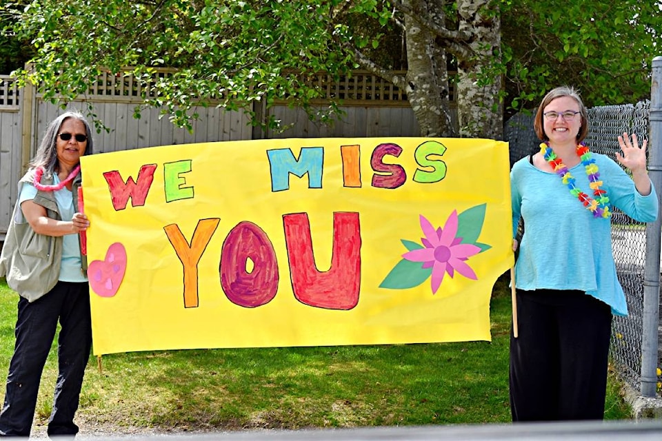 Pineridge Elementary School teachers and staff paraded in the school parking lot on May 14 to wave and say hello to students who came to visit at a safe social distancing or drive by. Seen here missing students are Lorraine Green and Morgan Sundin. (Photo: K-J Millar)