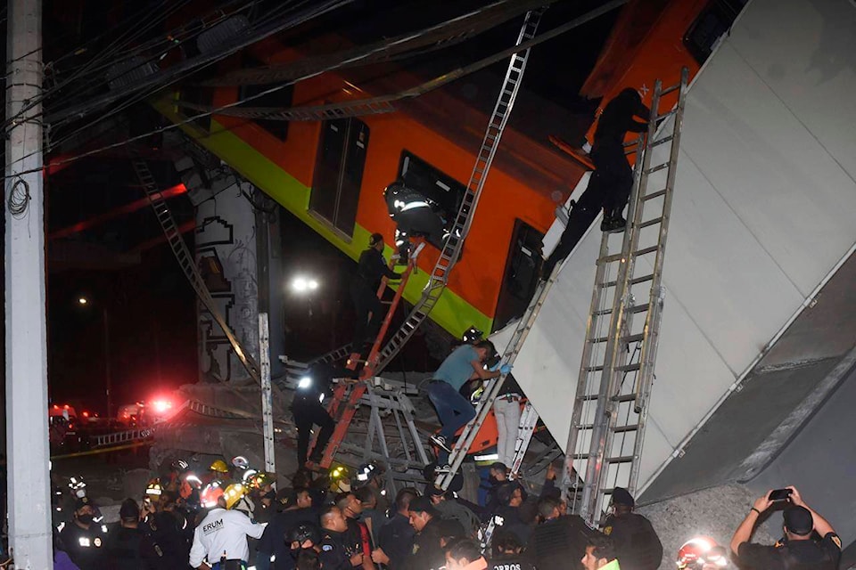 Mexico City fire fighters and rescue personnel work to recover victims from a subway car that fell after a section of Line 12 of the subway collapsed in Mexico City, Monday, May 3, 2021. The section passing over a road in southern Mexico City collapsed Monday night, dropping a subway train, trapping cars and causing at least 50 injuries, authorities said. (AP Photo/Jose Ruiz)