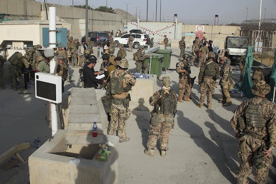 In this photo provided by the Ministry of Defence, members of the British and US military engage in the evacuation of people out of Kabul, Afghanistan on Friday, Aug. 20, 2021. (Ministry of Defence via AP)