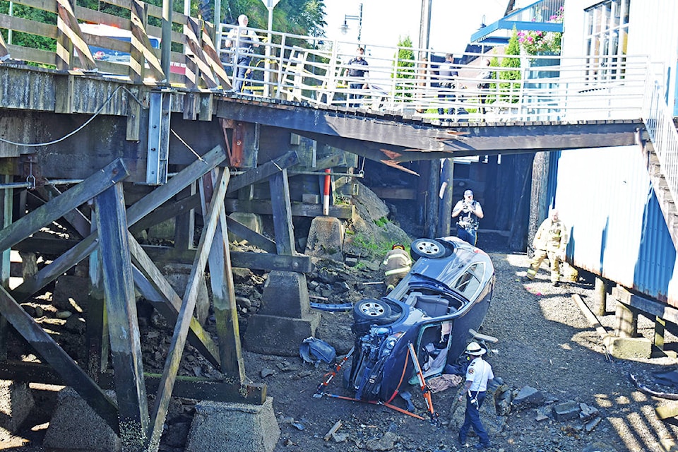 An SUV collided with the wooden guard rail snapping a pedestrian bridge, on Aug. 24 at the intersection of George Hills Way and Cow Bay Road, landing in the river embankment below Breakers Pub. (Photo: K-J Millar/The Northern View)