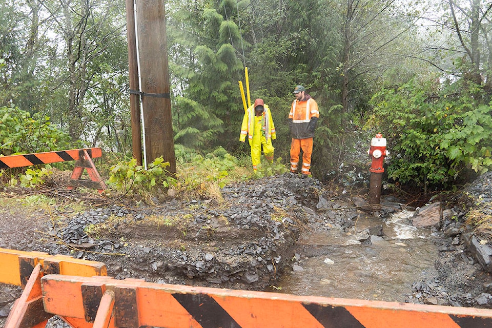 A BC Hydro and City of Prince Rupert worker assesses the damage from a creek that has overflow over the road and carved the ground out near a utility pole in the Prince Rupert Industrial Park on Sept. 24. (Photo: Norman Galimski/The Northern View)