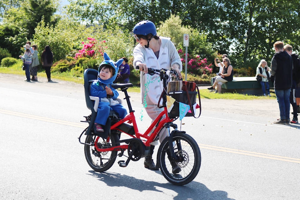 A woman and child riding a bike during Queen Charlotte’s Hospital Day parade on June 18. (Photo: Kaitlyn Bailey/Haida Gwaii Observer)