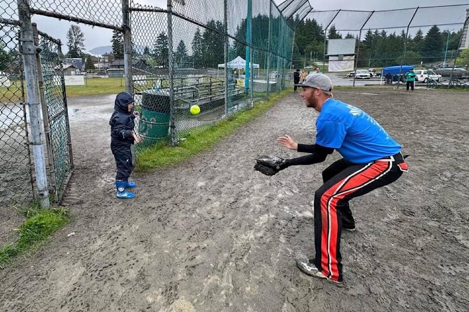 A young spectator returns the ball to a member of the Prince Rupert Port Authority team during the inaugural Kidsport Softball Tournament fundraiser.