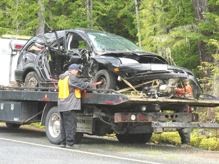 The remains of the car involved in the MVI is secured to a truck bed.
