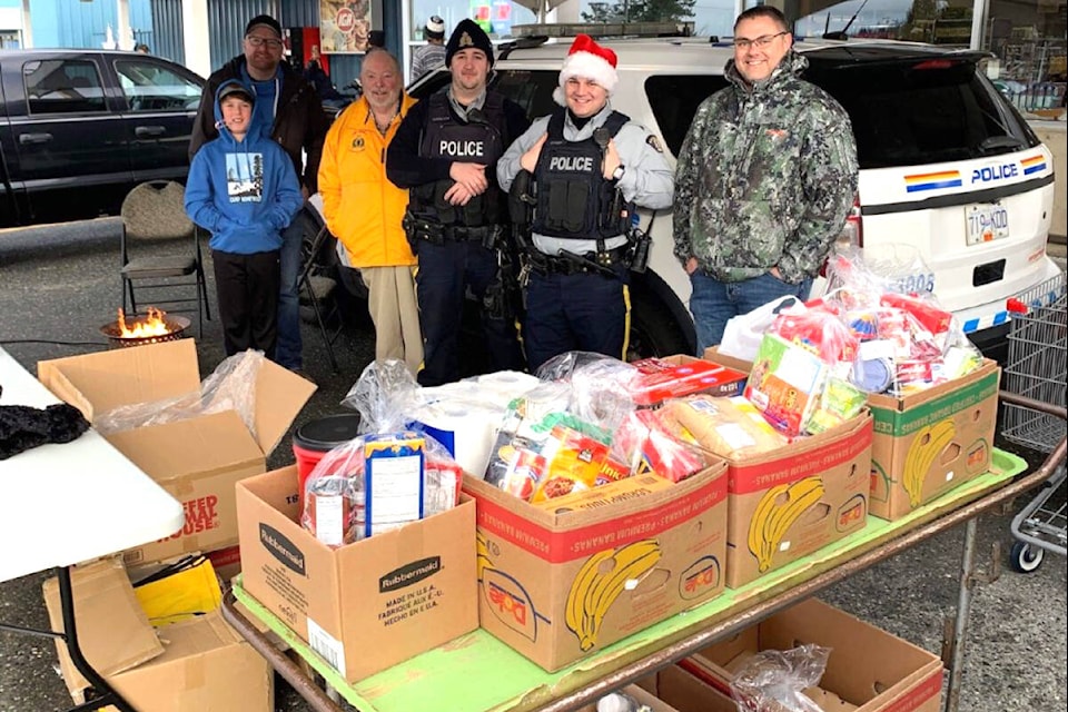 Port McNeill RCMP stop for a photo on Saturday (Dec. 10) outside the IGA at their annual December fundraiser, Cram The Cruiser, with all the proceeds raised going directly towards supporting the A-Frame Food Distribution programs. (Derek Koel photo)