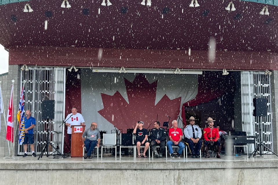 MLA for Kamloops-Thompson Peter Milobar speaking during Canada Day at Fadear Park in Barriere as a sudden downpour showered down. 