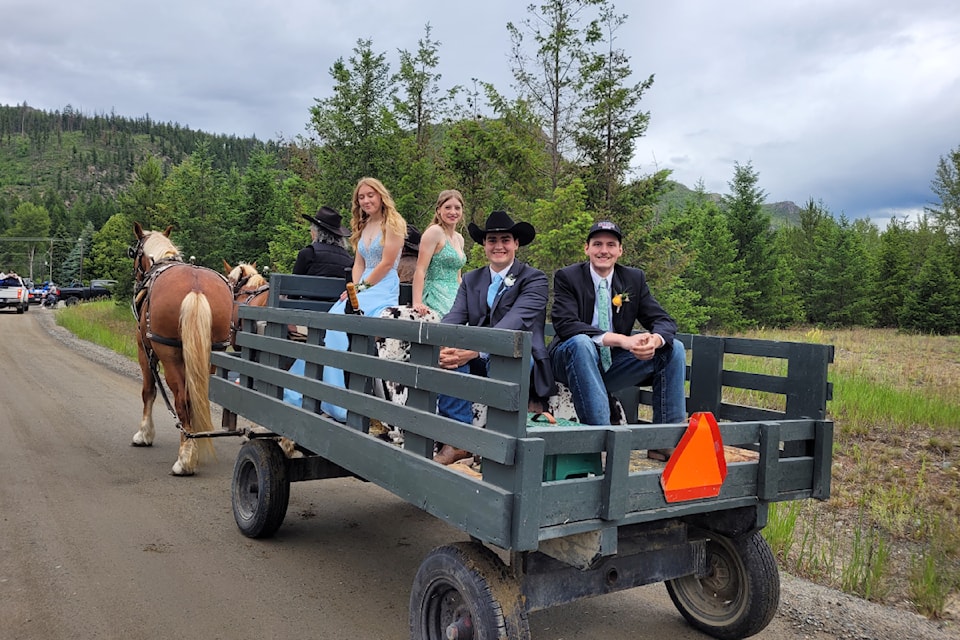 Graduates Alexis Nelson with date Hunter Zero
and graduate Bobby-Raye Farrow with date Logan Jones
on Dave and Cindy Stutts wagon as they roll through Barriere on June 15 under rain clouds (Photo by: Angeline Farrow) 
