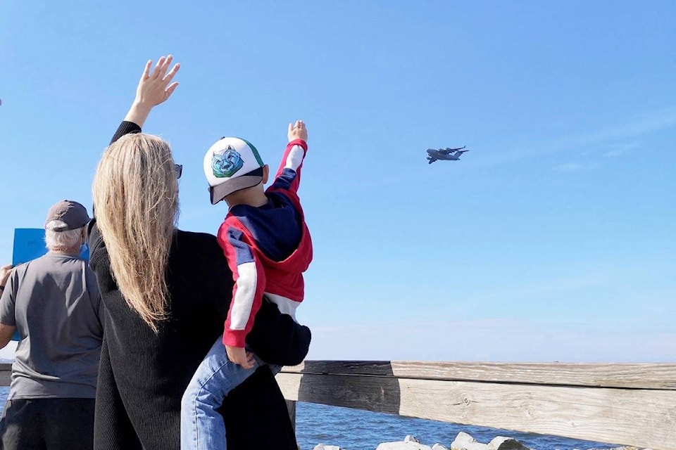 Four-year-old Ethan Fritz waves at his dad with his mom Alyssa, from the end of White Rock Pier. Pilot TK Minzak – who flies reserve for the U.S. Air Force, organized the fly-by after months of not being able to see Ethan due to border restrictions during the pandemic. (Tracy Holmes photo)