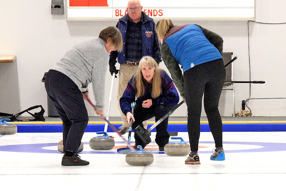 Barriere team skip Susan Bondar (center) encourages her sweepers Marie Gray (l) from Sicamous and her daughter Jocelyn Gray (r) from Whitehorse to ‘sweep hard’; while opponent Glenn Evans looks on. The Barriere team took first place in the Skins Bonspiel hosted at the Barriere Curling Rink on Saturday, Nov. 13. (Jill Hayward photo)