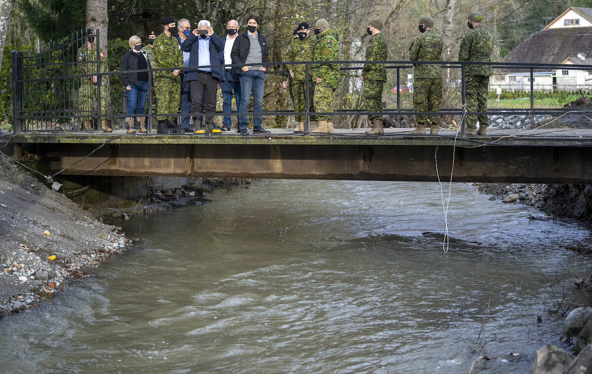 Prime Minister Justin Trudeau surveys the damage left behind from the flood waters in Abbotsford, B.C., Friday, November 26, 2021. THE CANADIAN PRESS/Jonathan Hayward