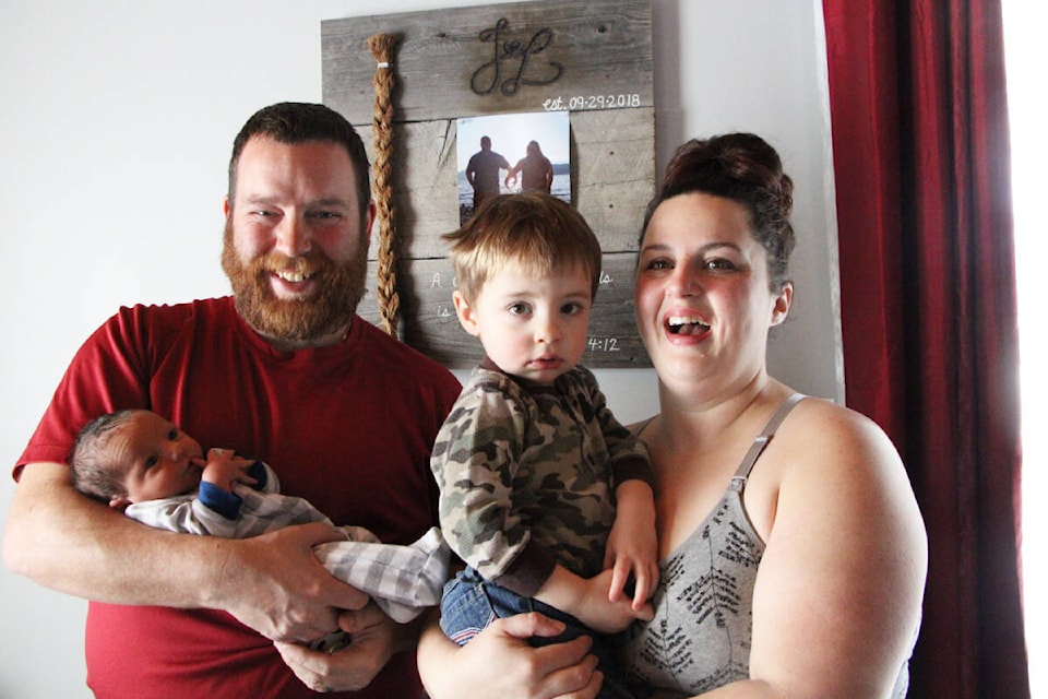 Laurence Doyle, left, cradles his newly born son Liam in his arms beside his eldest son Landon Doyle and his wife Joy. Liam was born at 100 Mile District General Hospital in a “fast and furious” birth earlier this month. (Patrick Davies photo - 100 Mile Free Press)