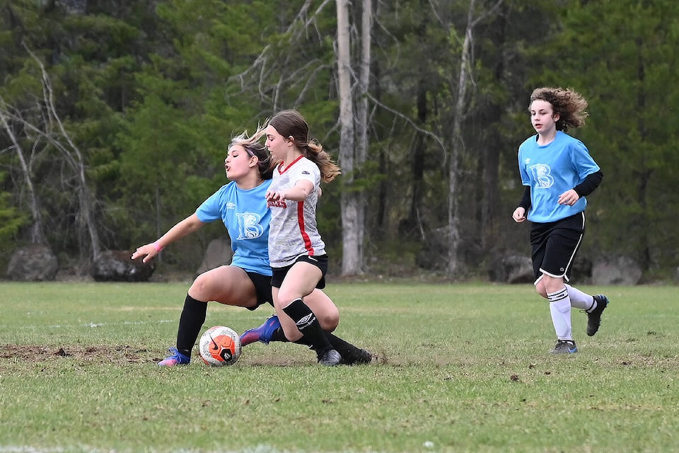 Barriere Secondary School player Mazey Munro (left) and a Clearwater Secondary School player take a tumble as they fight for the ball, with BSS player Lexie Kerslake behind. (Stephanie Hagenaars/Clearwater Times)