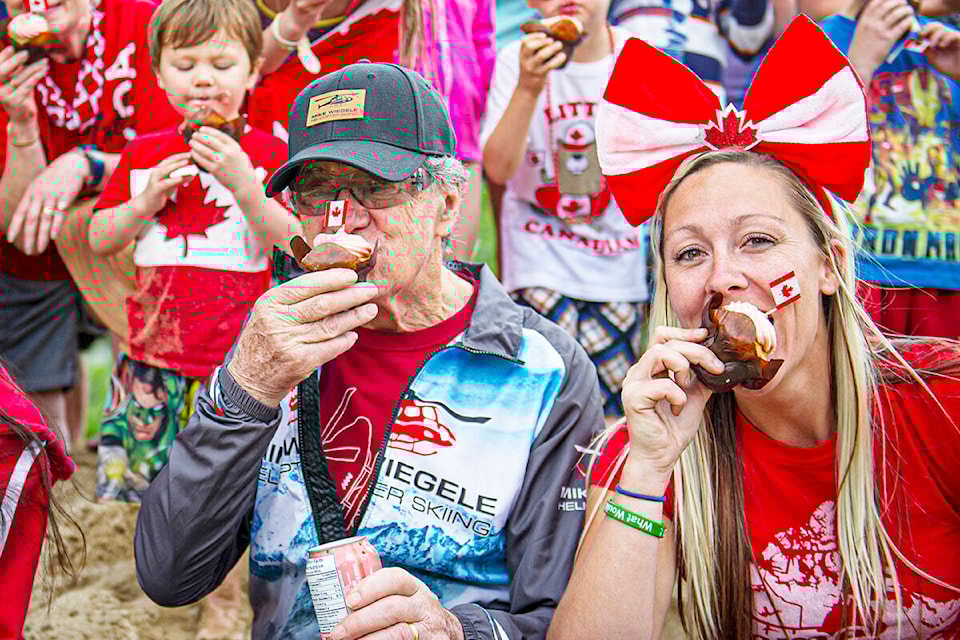 Mike Wiegele and event organizer Kasey Quinn chow down on some cupcakes at the Blue River Canada Day celebrations in 2019. (File photo)