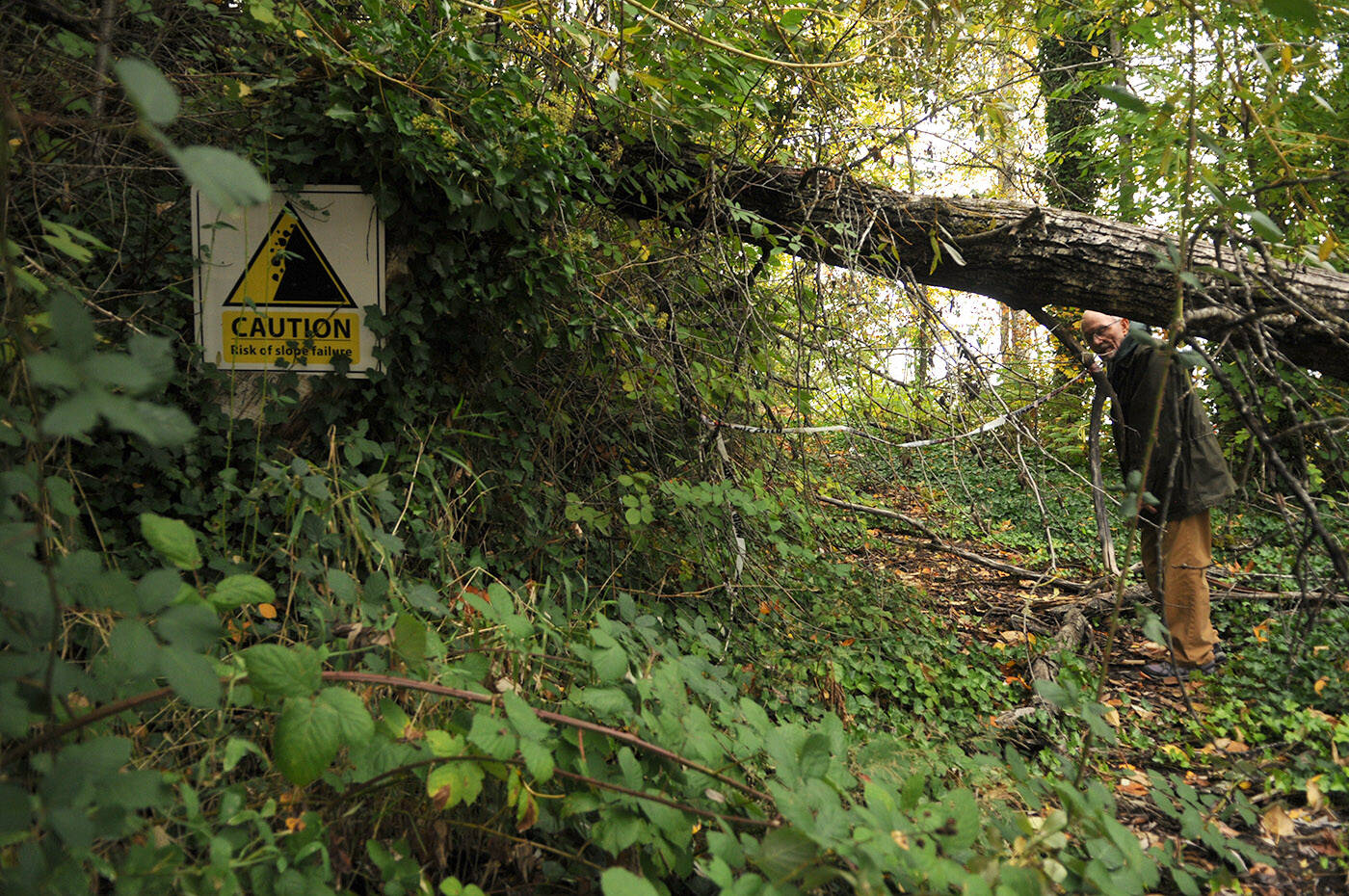 Richard Holmes stands at the end of his driveway near a sign which reads Risk of slope failure on Oct. 17, 2023. After nearly two years, he and other Chilliwack River Valley residents are still without resolution after their homes were deemed unsafe to live in, or destroyed, in the floods and mudslides in November 2021. (Jenna Hauck/ Chilliwack Progress)