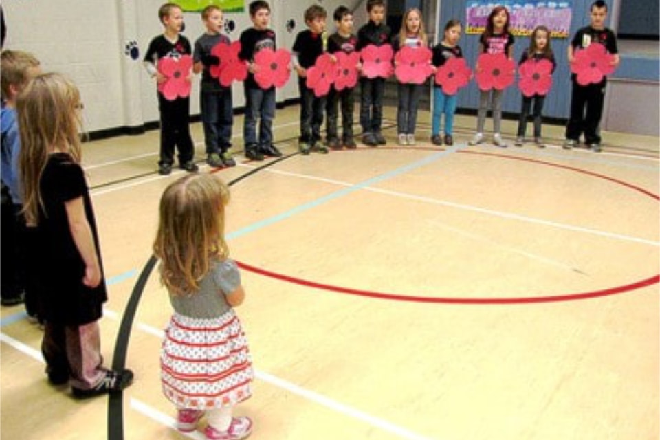 Barriere Elementary School (BES) students hold up poppies they have made during Remembrance Day ceremonies at the school on Nov. 8, 2013.