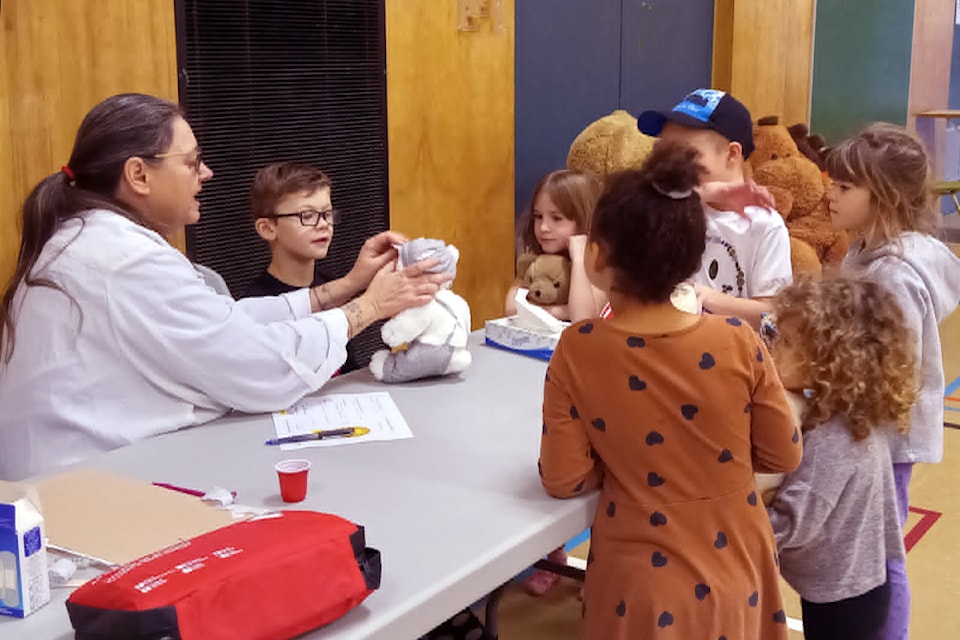 The Annual Teddy Bear Picnic in Barriere shows 'Doctor Goldilocks'  (Sherry Dilley) checking out the children's stuffies and issuing health certificates for the much loved stuffed friends during the 2024 event.