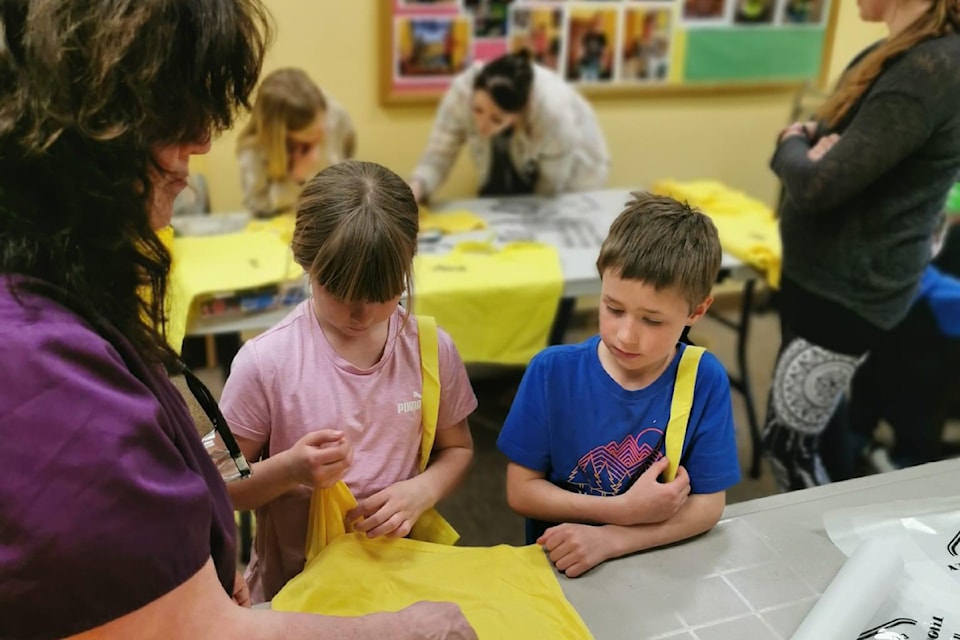 Learning about clothing was a fun activity assisted by Miette Koeneman of K33 Kreations and Deseray Van Sickle. Agate Valley Services donated the yellow shirts and the kids placed the logos and names on them. 