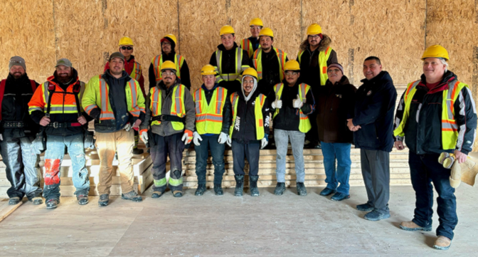 Nunavut Housing Minister Lorne Kusugak, third from right in front, joins members of the Nunavut Housing Corp, Nunavut Arctic College, Pewapun Construction Ltd., Nunavut Arctic College students and Kalum Wrightson, a Pewapun apprentice in Rankin Inlet, where three Nunavut Arctic College student residence duplexes are currently under construction.