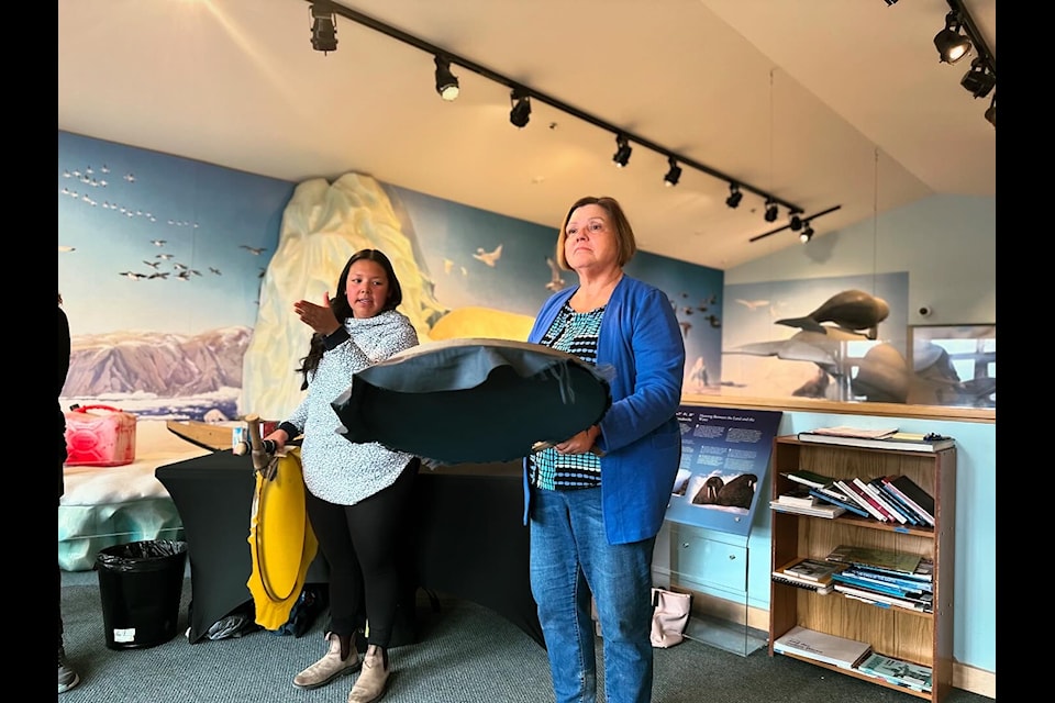 Leanna Wilson shows participant Diana Janosik-Wronski how to hold the drum properly. Women hold the stem of the drum higher on the handle.