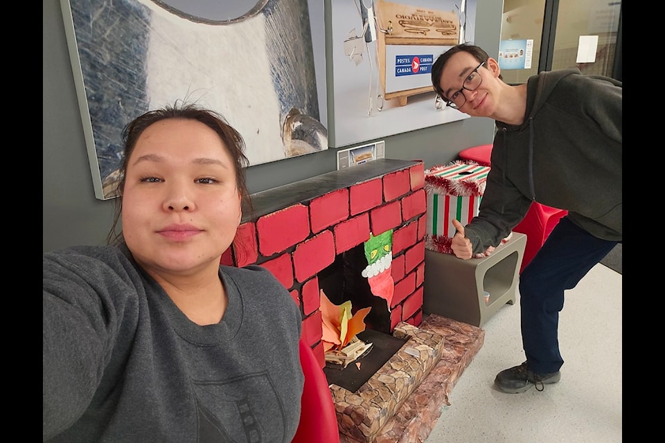 Maggie Kanayuk and Paul Power hang out by the chimney at the Iqaluit post office.